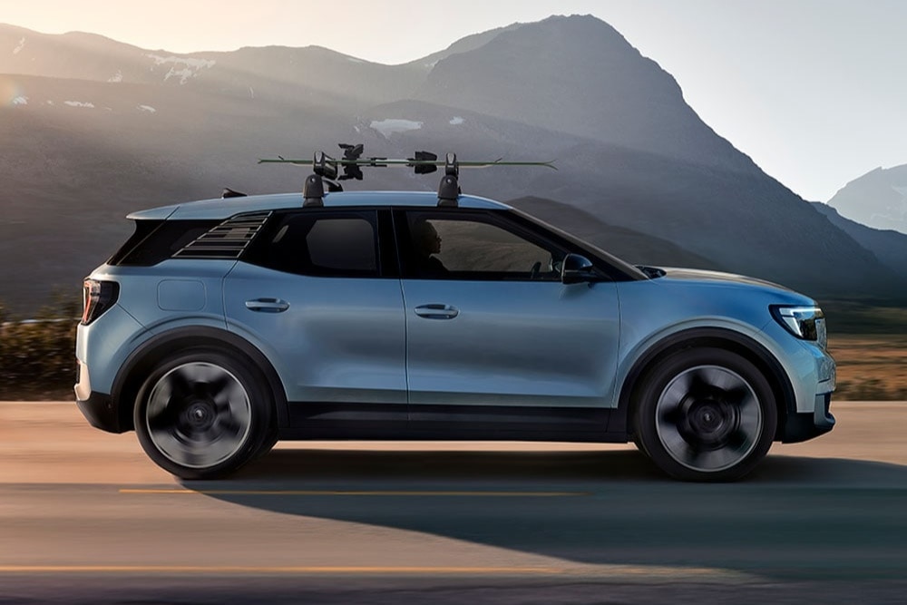 Kék Ford Explorer suhan a földúton, két kerékpárral a tetőtartón. 