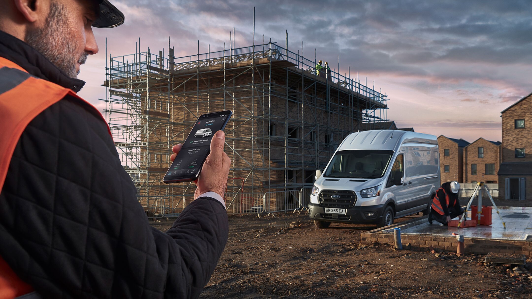 A man holding a phone with an open application Fordpass Pro