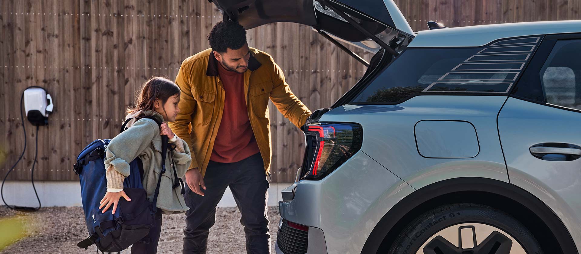 Család pakol egy kék színű elektromos Ford Explorer csomagtartójába.