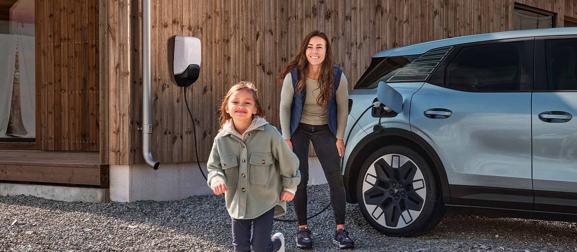 Egy család szórakozik, miközben elektromos Ford Explorerét egy kültéri EV otthoni töltővel tölti.
