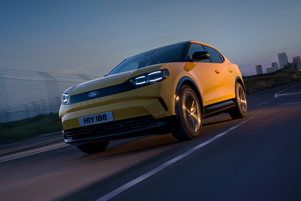 Sárga Ford Capri elektromos autó halad egy nyílt úton.