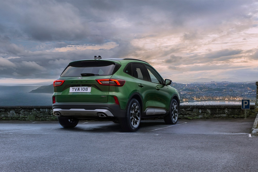 Zöld Ford Kuga öntöltő hibrid autó hátsó nézete.