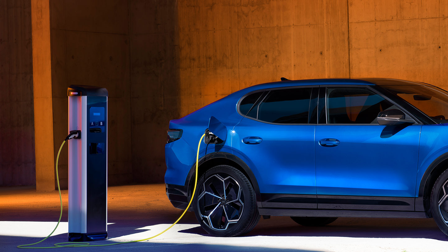 EV-töltőhöz csatlakoztatott kék Ford Capri elektromos jármű.