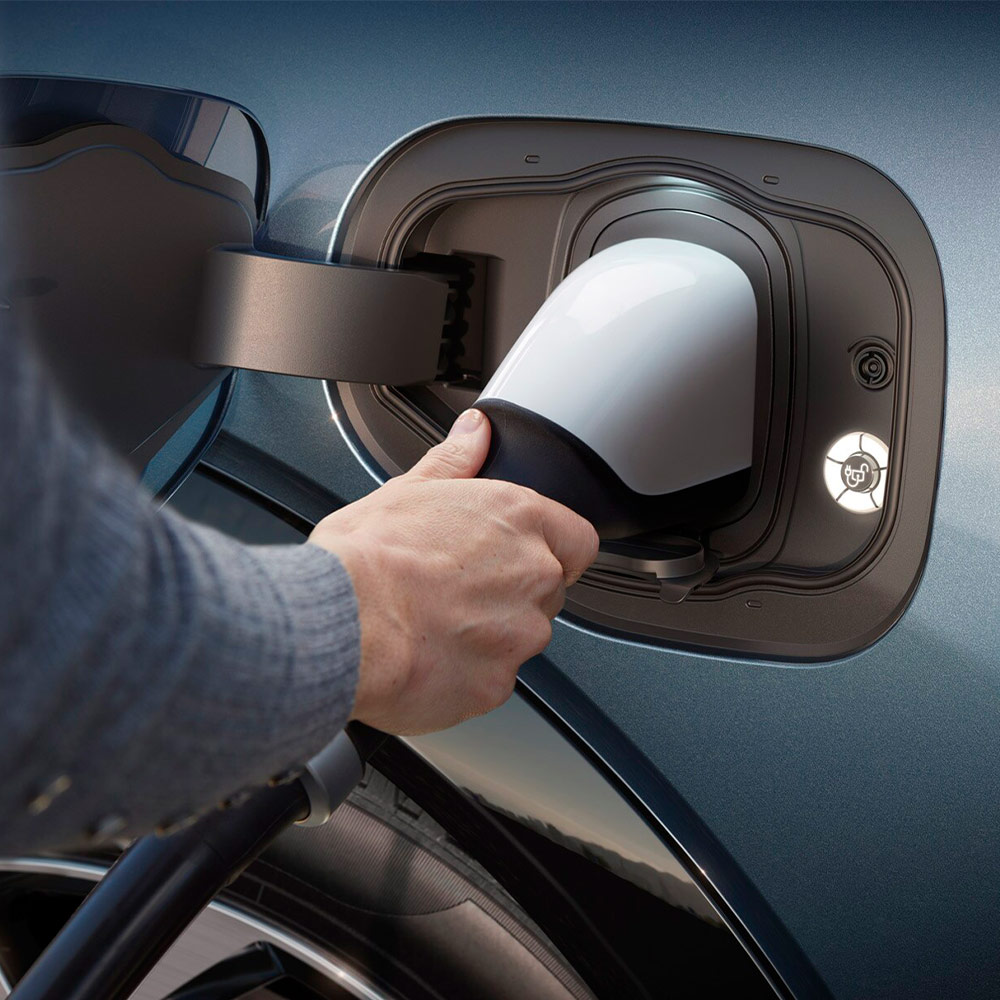 Egy személy ultragyors elektromos töltőt csatlakoztat egy Ford elektromos autóhoz.