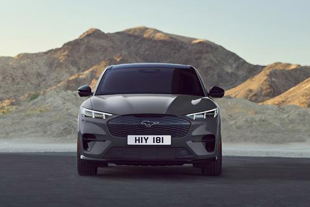 Elölnézetből látunk egy hegyvidéki táj előtt parkoló fekete Ford Mustang Mach-E-t.