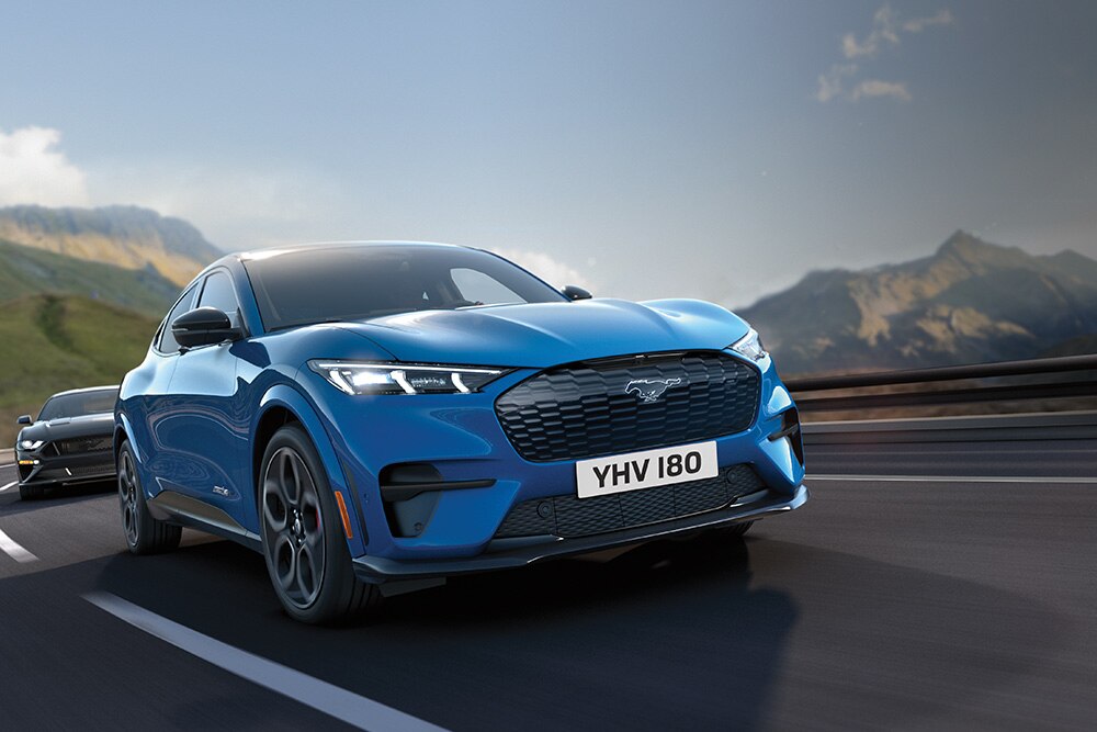 Kék Ford Mustang Mach-E halad az autópályán.