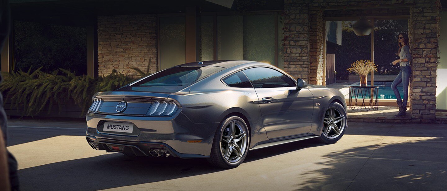 Ford Mustang parked outside luxury home