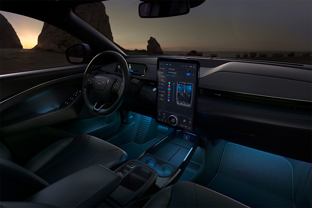 A Ford Mustang Mach-E utastere éjjel. A 15,5"-os SYNC 4 érintőképernyő és a LED-izzós hangulatvilágítás kék színű.
