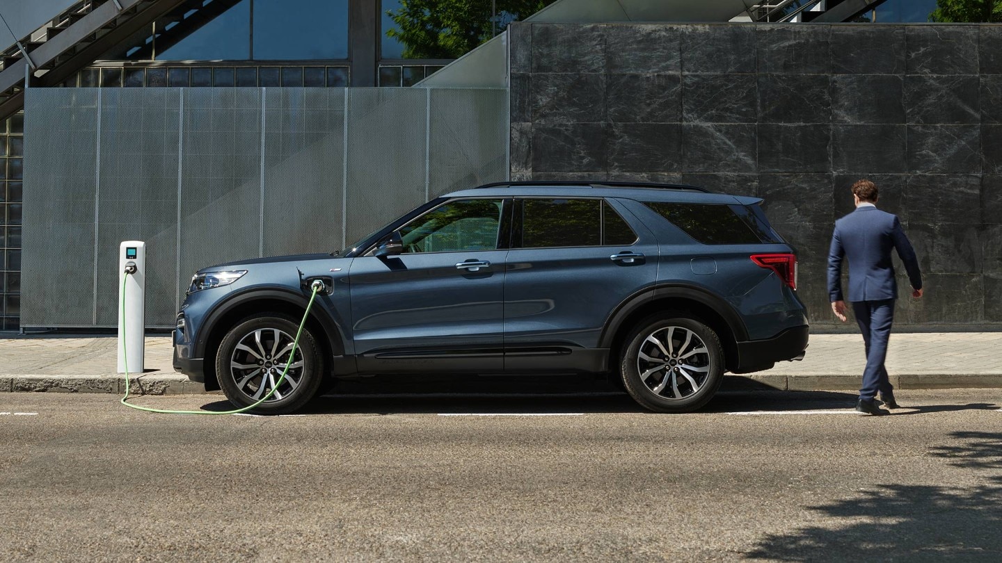 Man charging Ford Explorer at a public charging point