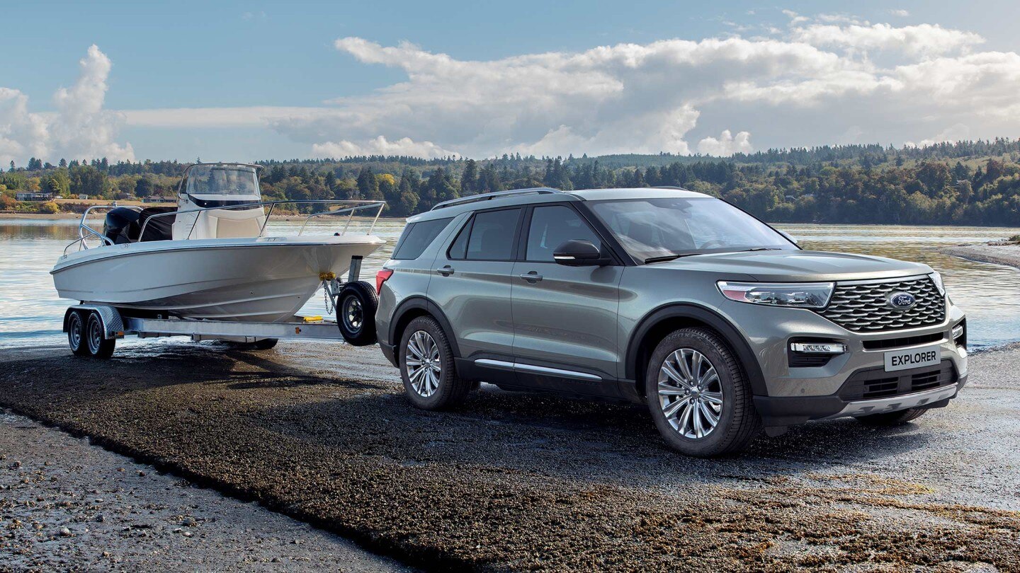 Ford Explorer with trailer parked near lake