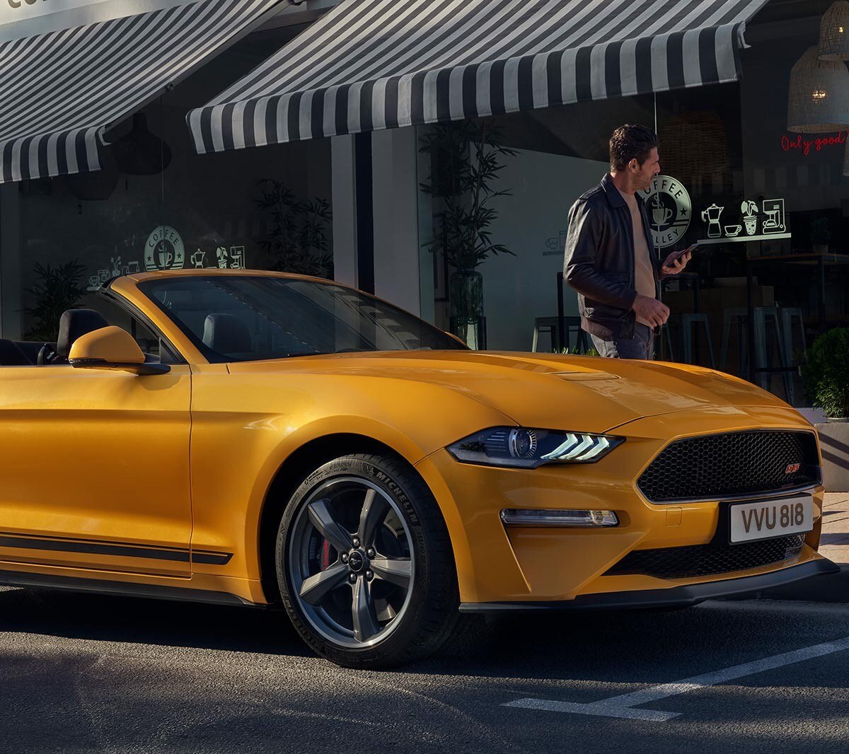 Ford Mustang GT in motion driving on the road above a rural village