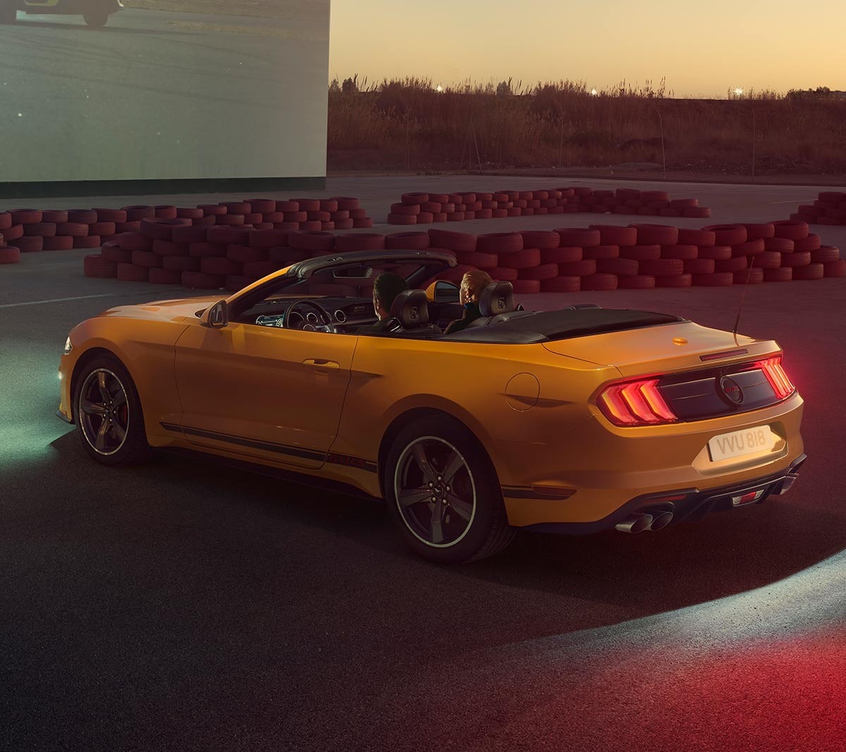 Ford Mustang GT in motion driving on the road above a rural village