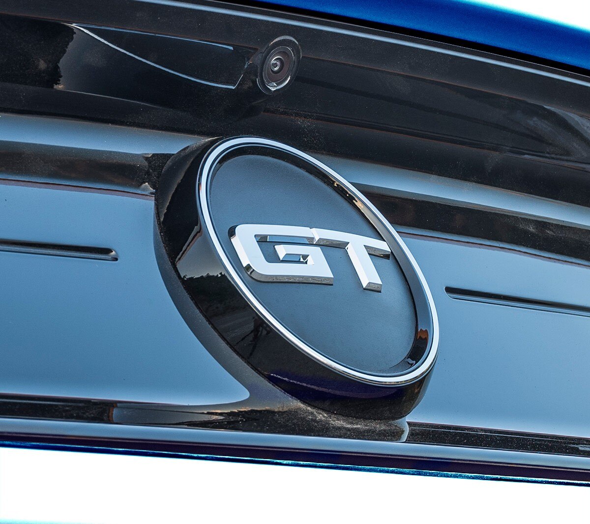 Blue Ford Mustang GT parked by grill gate