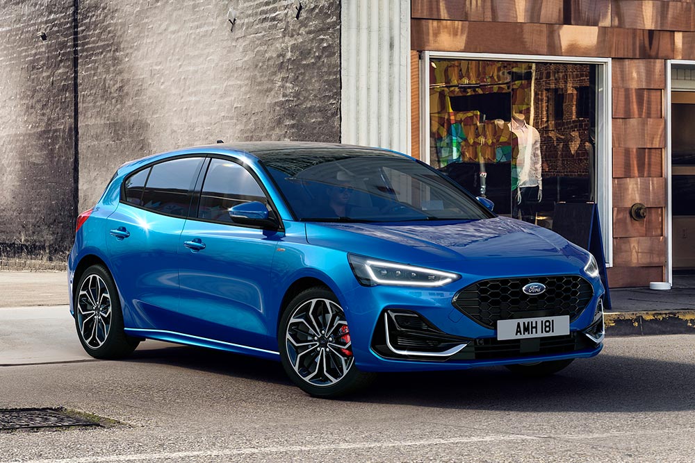 Kék Ford Focus parkol egy városi utcán.