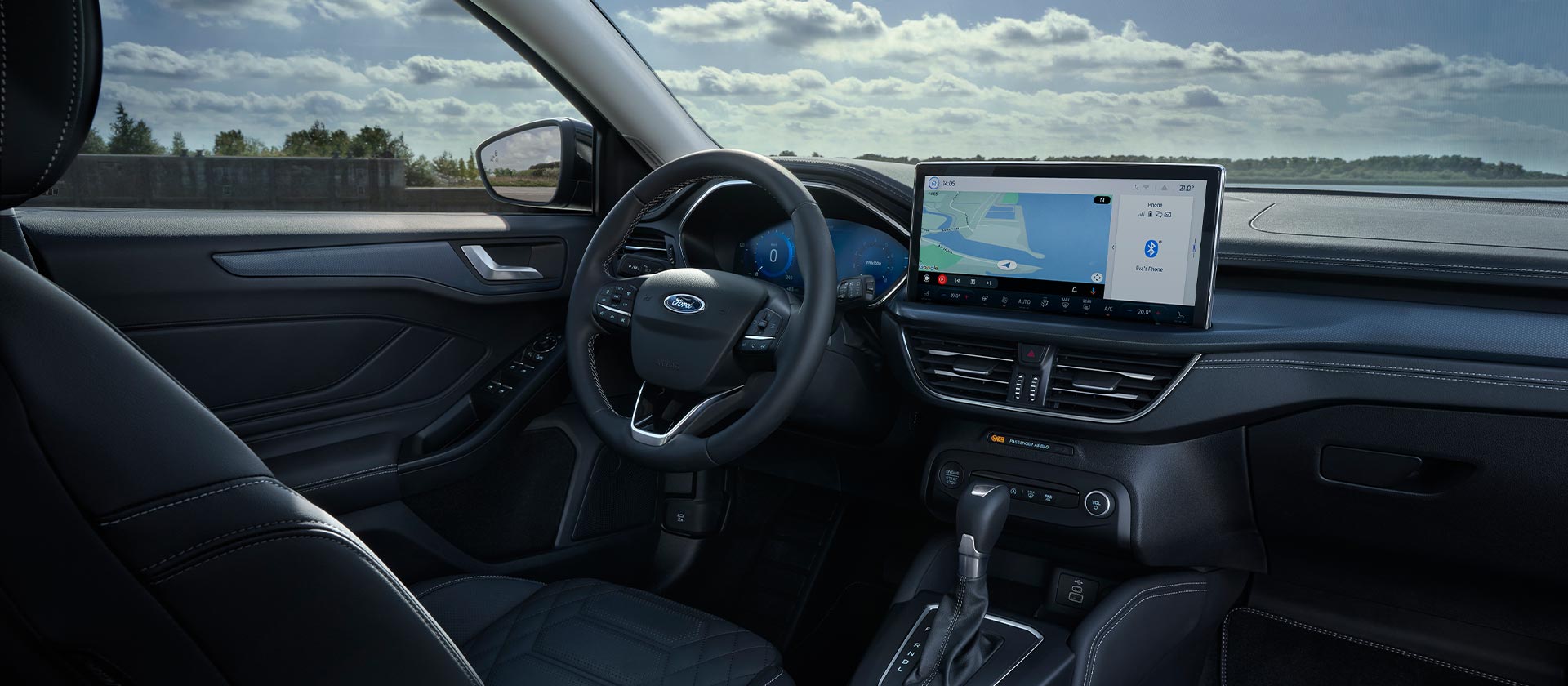 A Ford Focus belső nézete a műszerfallal, a navigációs rendszerrel ellátott infotainment képernyővel és a kormánykerékkel.