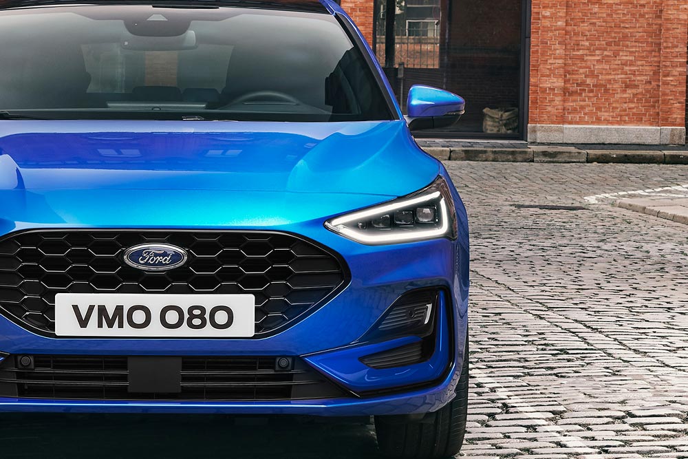 Kék Ford Focus elölnézetből, a fényszórókkal és a hűtőráccsal.