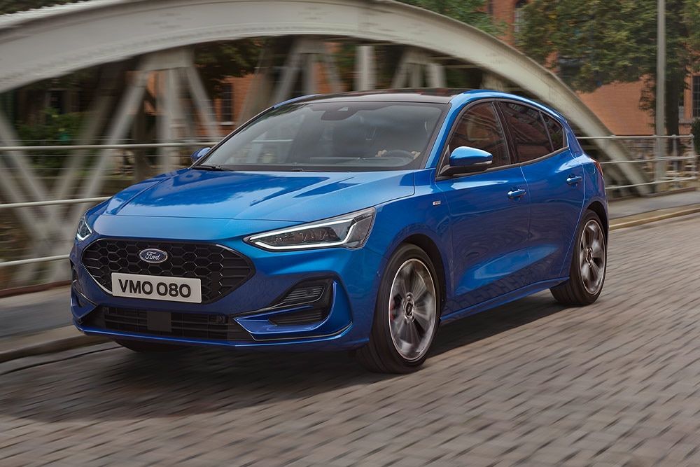 Kék Ford Focus kombi halad át egy hídon.