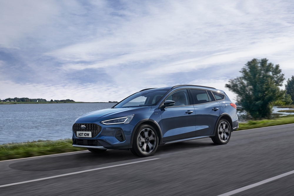 Egy kék Ford Focus® kombi halad egy tó mentén.