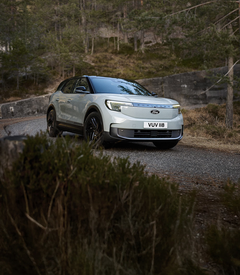Ezüst Ford Explorer kanyargós hegyi úton.