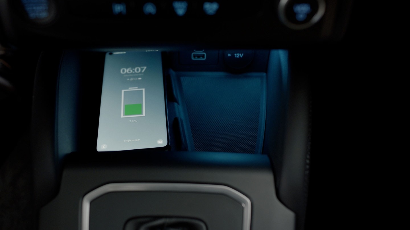 Smartphone being charged inside a car's compartment