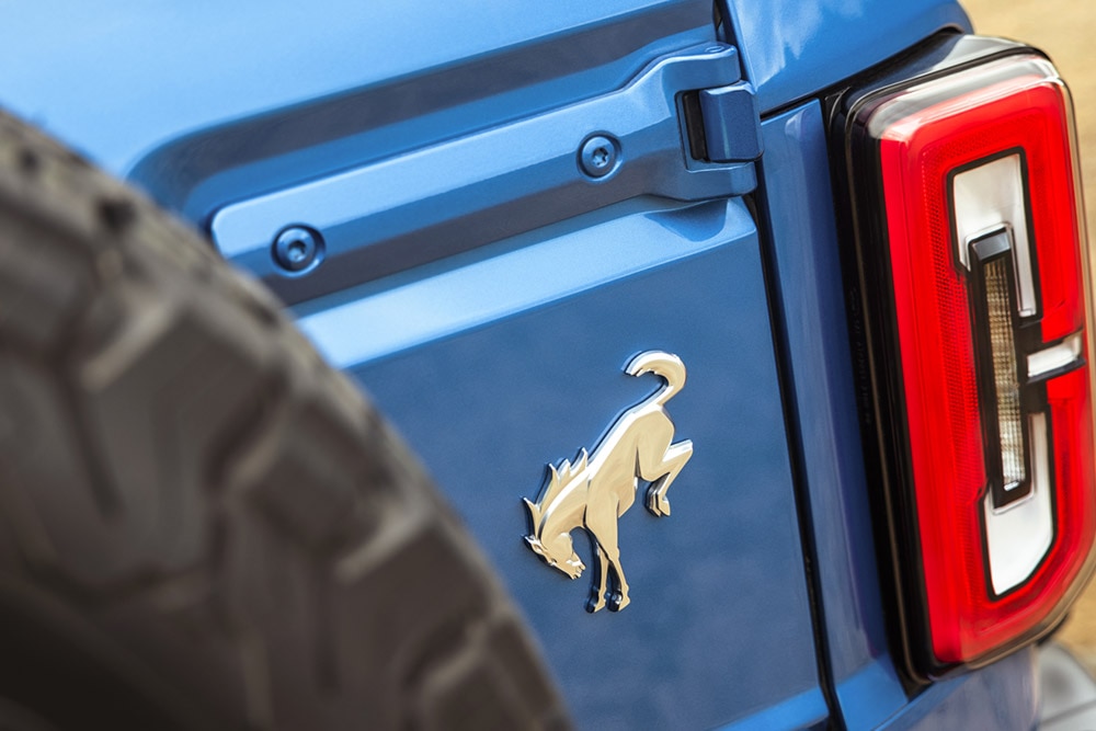 Közelkép egy kék Ford Bronco hátsó részén található logóról.
