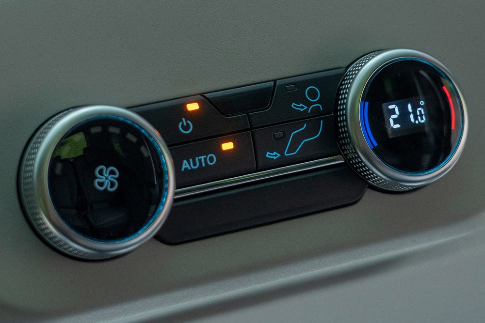 Közelkép a jármű klímavezérlő gombjairól.