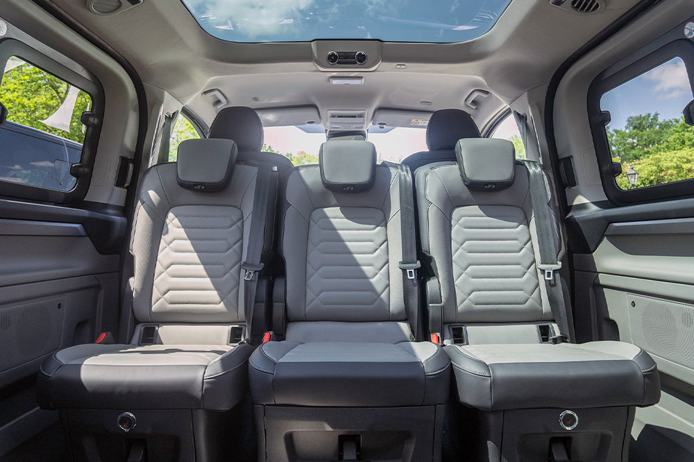 Egy jármű belső tere, a szürke hátsó üléseket és a panorámatetőt mutatva.