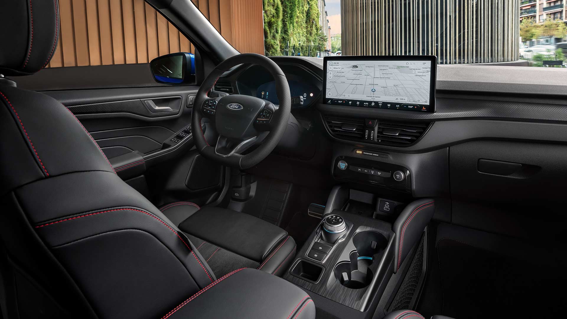 A Ford Kuga belsejében a Ford emblémás kormány, a SYNC® 4 érintőképernyő és a fekete ülések piros díszvarrással.