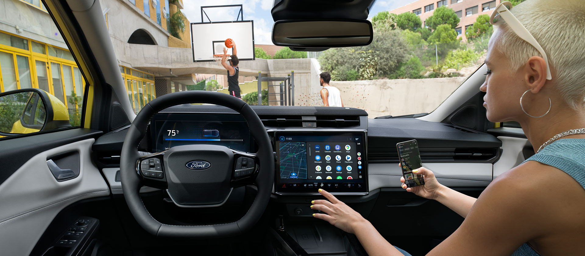 Az elektromos Ford Puma Gen-E® utasterében egy személy a telefonját vezeték nélkül összekapcsolja a nagy érintőképernyővel.
