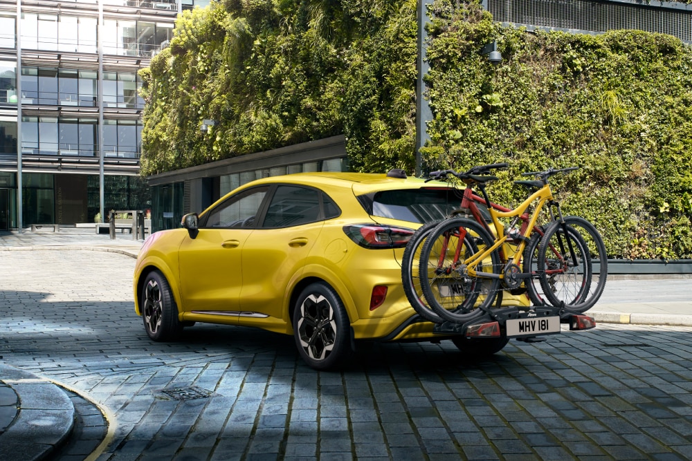 Sárga Ford Puma Gen-E vonóhorogra szerelhető kerékpártartóval