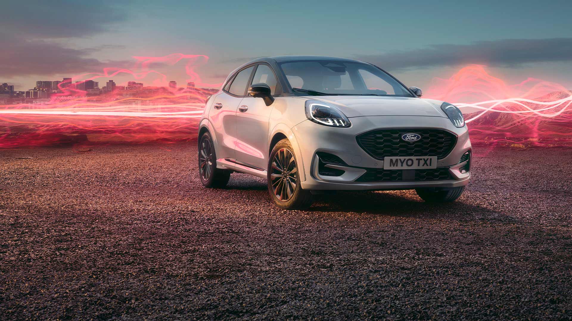 Fehér Ford Puma Sound Edition álló helyzetben, a háttérben piros hanghullámgrafikával.
