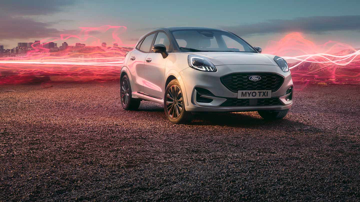 Fehér Ford Puma Sound Edition álló helyzetben, a háttérben piros hanghullámgrafikával.