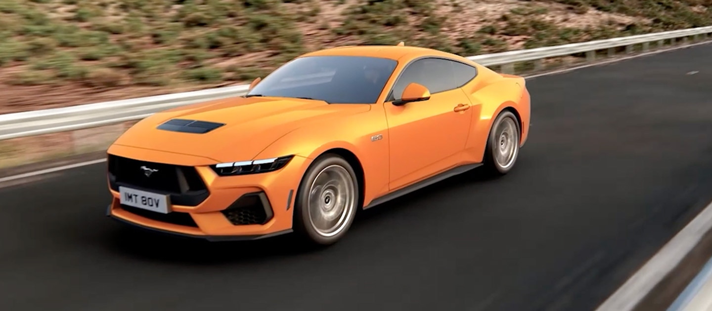 Ford Mustang GT Fastback Orange Fury színben, hegyi úton haladva