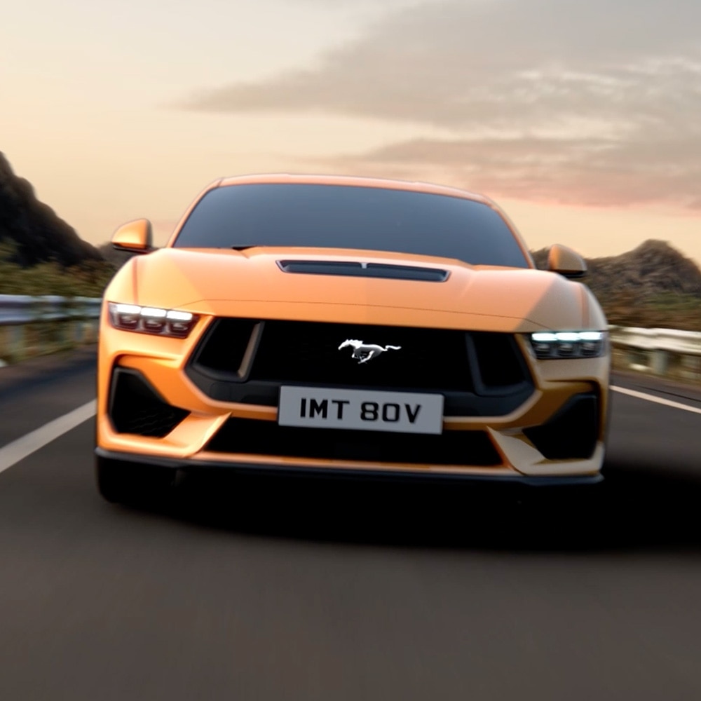 Elölnézet egy narancssárga Ford Mustangról, közelképen a fényszórók, a hűtőrács és a Mustang-jelvény