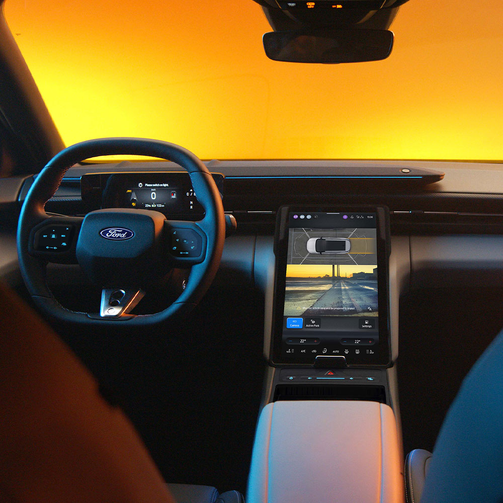 A Ford Capri® érintőképernyője a 360°-os kamerarendszer és a parkolási segédlet osztott képernyős nézetét mutatja.