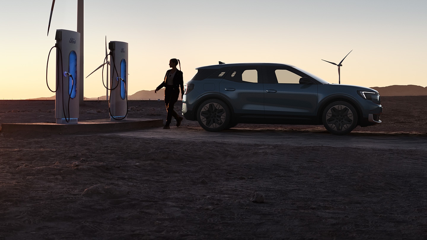 A person charging the Ford Explorer® at sunset