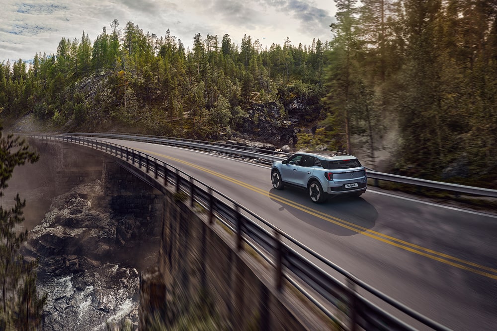 Egy kék Ford Explorer családi SUV hegyvidéki tájon halad.