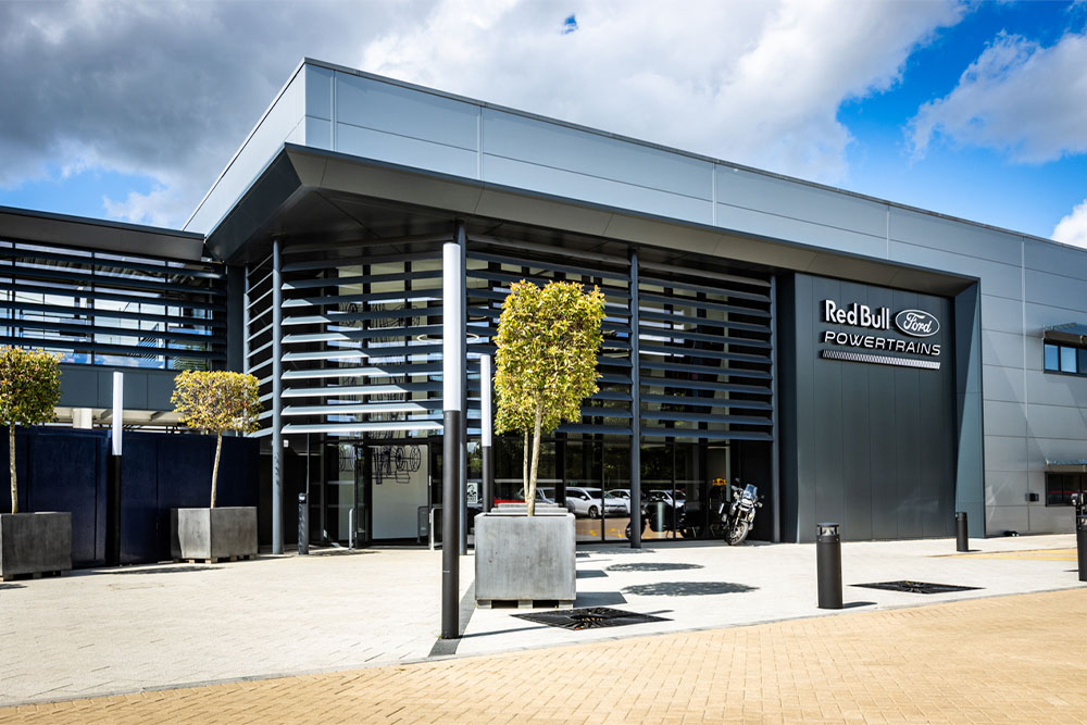 A Red Bull Ford Powertrains központi irodája – egy modern épület, amelynek homlokzatán a vállalat logója látható.