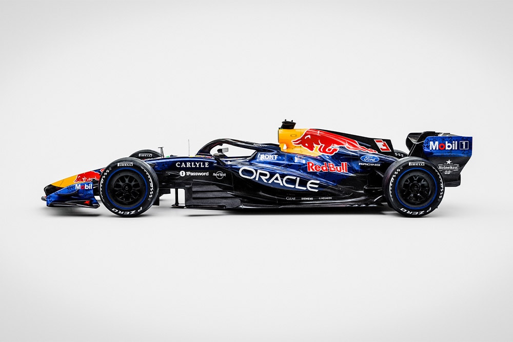 Karcsú Red Bull Ford Formula 1 versenyautó tiszta fehér háttérrel, szponzorlogókkal, Ford és Red Bull logókkal.