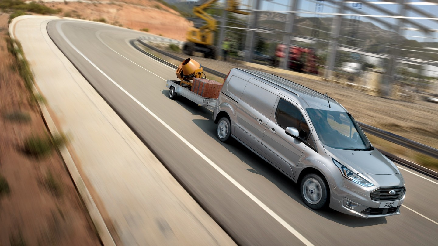 Ford Transit Connect towing a trailer around bend