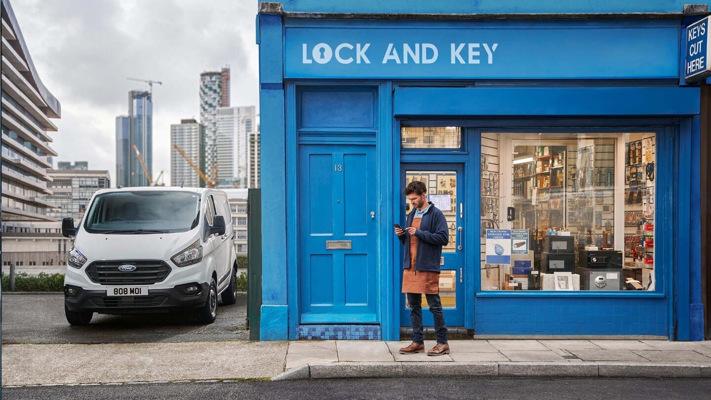 Trader in front of key shop with Transit Custom parked next to shop