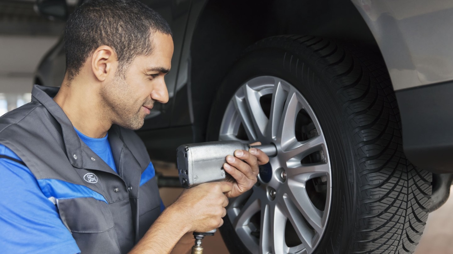 A mechanic checking the chassis cab wheel