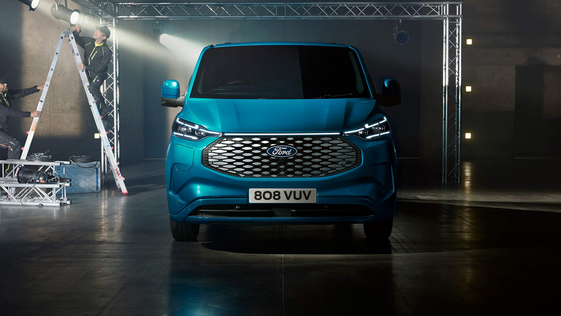 Egy kék Ford E-Transit Custom elektromos áruszállító, elölnézetből.