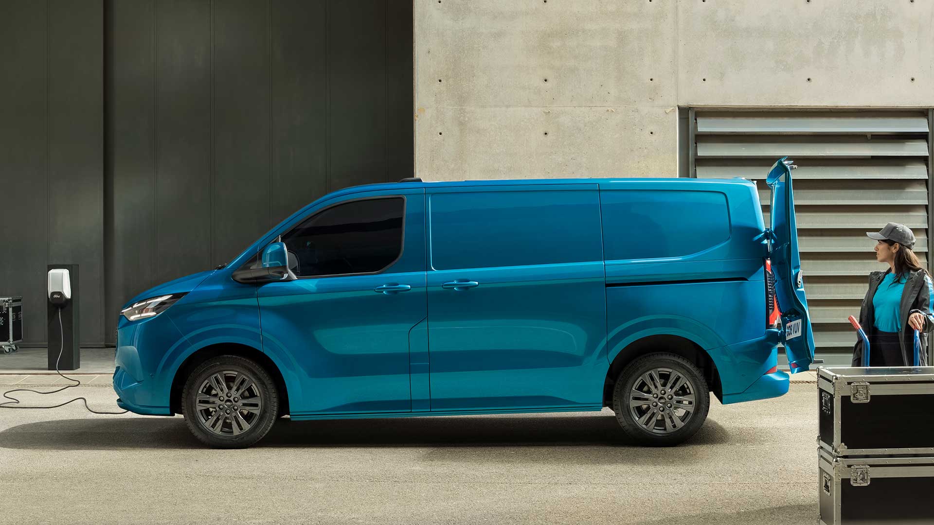 Egy kék Ford E-Transit Custom elektromos áruszállító töltés közben.