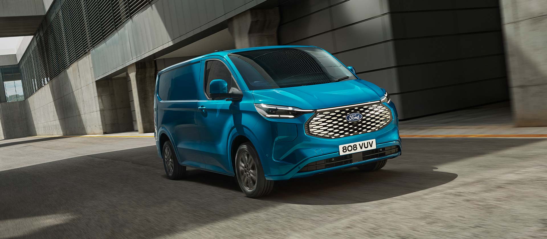 Egy kék Ford E-Transit Custom elektromos áruszállító, oldalnézetből.