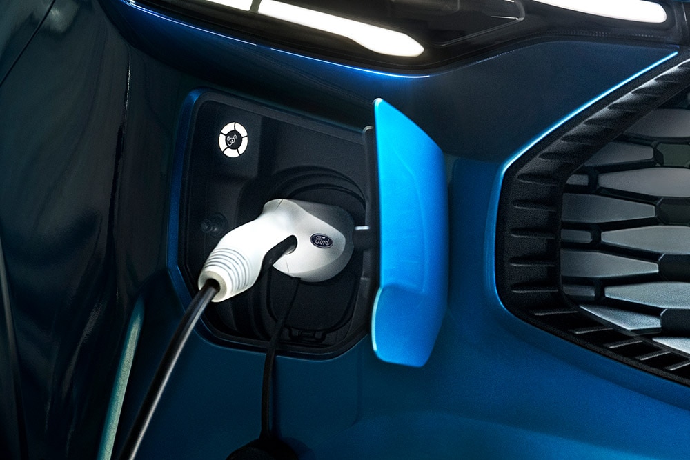 Egy kék Ford E-Transit Custom elektromos áruszállító töltőportja.