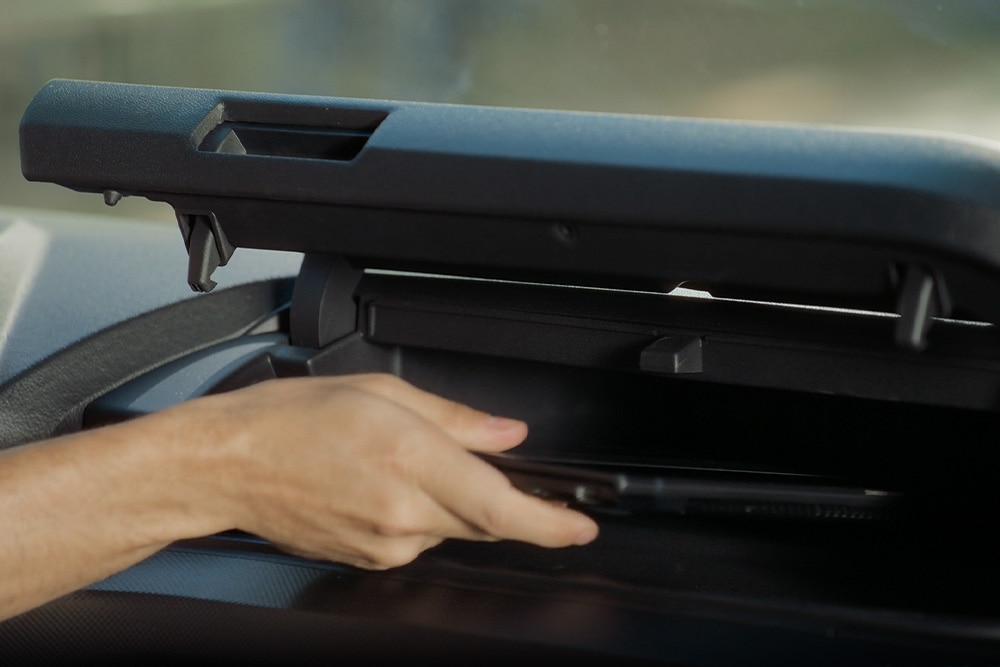 Hand opening a storage compartment in Ford E-Transit Custom electric van.