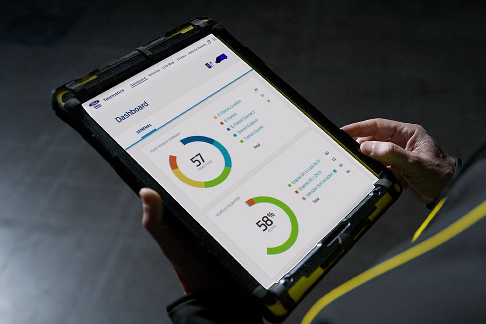 Valaki egy a Ford Pro járműadatait megjelenítő tabletet tart a kezében.