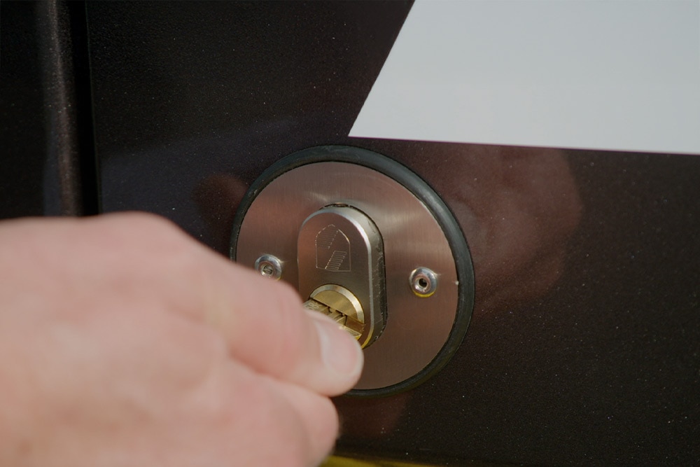 Valaki kézzel kulcsra zárja az áruszállító ajtaját.