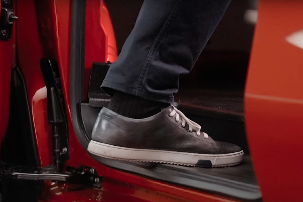 Valaki belép egy Ford E-Transit Custom elektromos áruszállítóba.